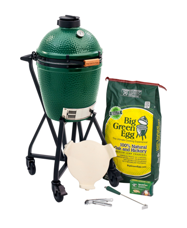 Large green egg barbecue with two bags of charcoal positioned beside it, ideal for grilling enthusiasts.